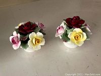 Pair of Aynsley floral porcelain figurines with detailed red, yellow, and pink flowers and green leaves.