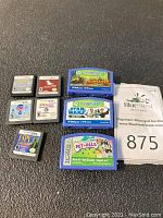 Photo showing 8 Nintendo DS game cartridges and 3 Leapster game cartridges on black background.