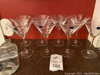 Eight etched Mikasa martini glasses with Mikasa logo stickers, shown on counter, positioned behind Gray Goose vodka bottle.