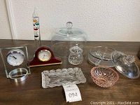 Overview of all items on table including crystal dishes, clocks, and barometer