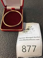 Top view of bangle inside red velvet box showing overall shape and color