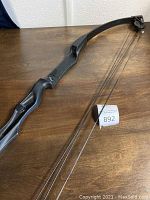 Overview of the Pearson compound bow showing the frame and string, placed on a wooden surface.