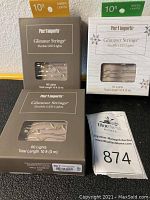 Photo showing 10 foot amber and green Glimmer Strings LED light boxes from Pier One Imports, new in box, 60 lights each.