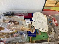 Photo of unopened box showing bundled wooden stage components, fabric curtains, and multiple marionette puppets wrapped in plastic.