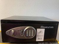 Front view of the black SentrySafe fire proof safe showing the electronic keypad and keyed bypass lock with key inserted.