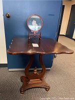 Square dark rosewood table with curved edges, lyre base and turned finial support, one side of table top can be lifted.