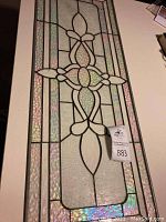 Full view of entire stained glass panel showing rectangular shape and central motif