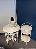 Photo showing the white wicker octagon table, wicker stand with lid, and small mirror with basket grouped together near a blue door.