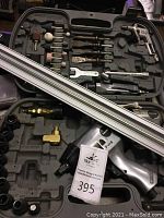 Overview of Coleman Powermate air compressor tool kit with various grinding and sanding bits, small wrenches, and pneumatic tool.