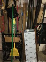 Photo showing garage creeper headrest, Workmate 225, yellow dustpan, green broom