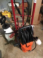 Ortho hand pump sprayer and Wholesun compact pressure washer with hose and wand visible