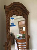 Front view of full-length medium oak cheval mirror showing decorative carved wood frame and top arch.