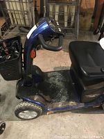 Side view of blue Pride mobility scooter on barn floor