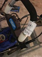 Pressure washer handle close-up showing electric start labeling and auction tag.