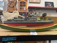 Two painted wooden boat models displayed side by side