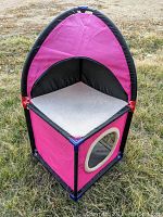 Purple and black collapsible fabric cat house with circular window and cushioned floor
