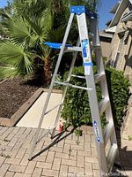 Full view of the 6-foot Werner aluminum step ladder standing outdoors on a paved surface.
