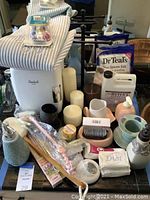 Full lot view showing mini fridge, candles, soap holders, lotion and bath salt packages.
