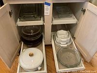 Photo showing various sizes of clear glass rectangular baking dishes stacked inside a cabinet