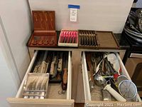 Overall view of three drawers containing various cooking and cutting utensils.