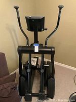 Front view of a black New Balance elliptical trainer showing the digital console and handles.