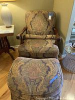 Armchair and ottoman set placed on wood flooring, showing fabric pattern and wood arms