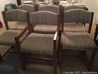 Photo showing six dining chairs; two captains chairs with armrests and four regular chairs, all with wooden frames and striped fabric upholstery