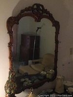 Full view of the large wood framed mirror showing its overall size and reflection of room surroundings.