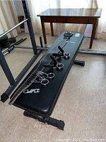 Complete side view of RE Fitness weight bench, lifting belt, barbell collars and wrench placed on bench