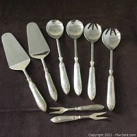 Full view of all six serving utensils: two cake servers, two salad server spoons, two salad server forks, and two olive/pickle forks.