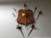 Full set of six miniature swords, spear and shield mounted on plaque with rough fabric cover and red line pattern