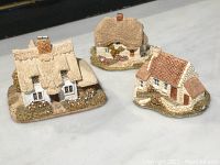 All three Lilliput Lane cottages displayed together on a flat surface, showing the overall size and detail.
