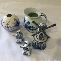 Photo showing the full assortment of 5 novelty Delftware pieces: 3 windmills, 1 pitcher, 1 spherical vase or lamp shade.