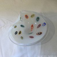 Top-down photo of one milky white Murano glass candy dish showing multicolored embedded medallions and the shape.