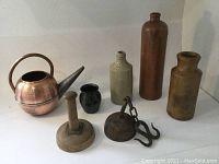 Photo showing the entire lot including copper teapot, butter stamp, meat hook, and three earthenware items.