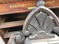 Close-up of cabinet front showing “Shannon Filing Cabinet” lettering and edge of decorative piece.