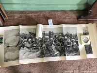 Black and white large vintage print showing a detailed British Army battle scene with soldiers firing cannon artillery, laid out on carpeted floor with some damage visible.