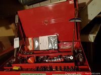 Full view of assorted tools in red metal organizer tray.