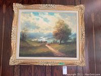 Full frontal view of painting and ornate gilded frame