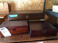 Photo of three wooden boxes on a shelf showing size differences and damages.