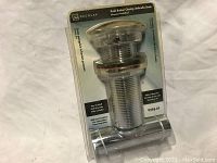 Chrome polished push button umbrella drain in original packaging showing full product.