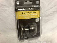Gate House dummy knob in original vinyl packaging showing front label and knob with matte black finish.