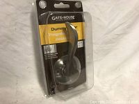 Clear packaged Gatehouse dummy lever door handle in silver finish with round rose base, viewed from the front and side.