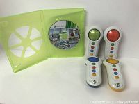 Xbox 360 game disc titled Family Game Night inside the translucent green game case, with four Xbox 360 Buzzers showing each with a different colored orb button: green, red, blue, yellow.