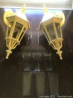 Pair of yellow vintage metal coach light fixtures with four glass panels each laid flat with loose glass panels beneath