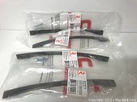 Four metal cabinet pulls in antique nickel finish in sealed plastic packaging with labels and screws visible.