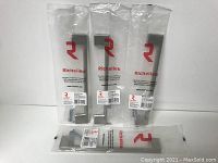 Four individual Richelieu pulls in clear packaging showing front view and screws included