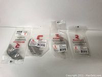 Four individually packaged Richelieu metal pulls in brushed nickel finish, displayed sealed in clear plastic packaging with branding and barcode labels visible.