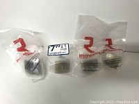 Four unopened Richelieu Hardware knobs in original plastic packaging with price sticker visible on one.