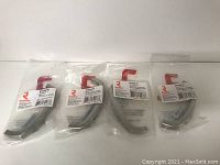 Four new Richelieu metal pulls in sealed plastic packaging, shown side by side on white background.